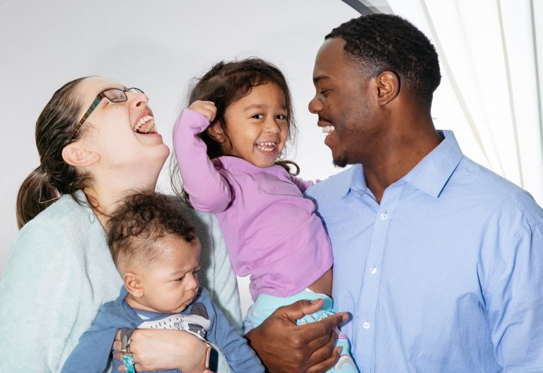 Diverse family of four laughing and having fun together